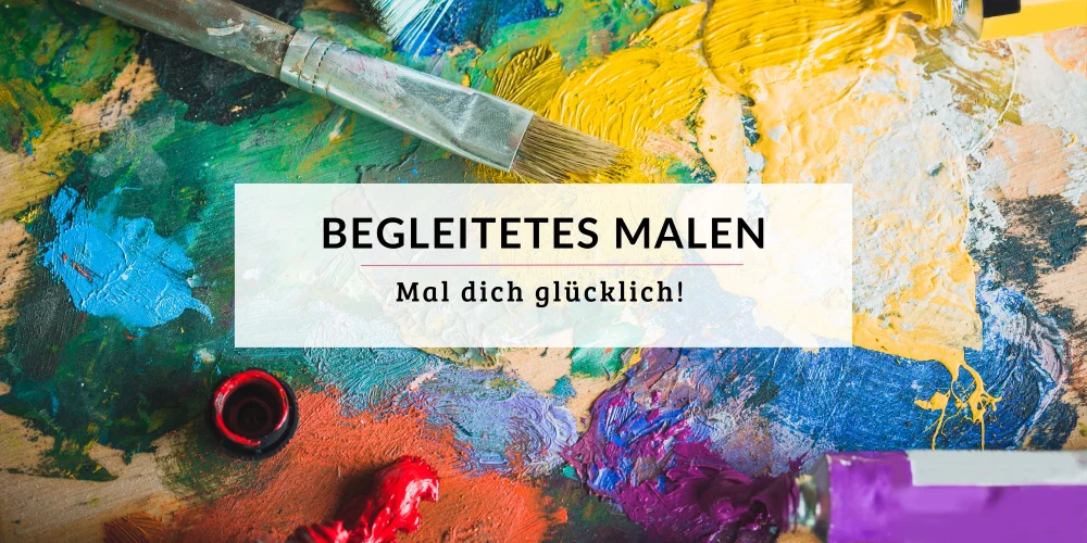 Bunte Ölfarben auf einer Holzpalette mit bunten benutzten Pinseln und kleinen Farbtuben. In der Mitte ein Schriftzug: Begleitetes Malen - Mal dich glücklich!